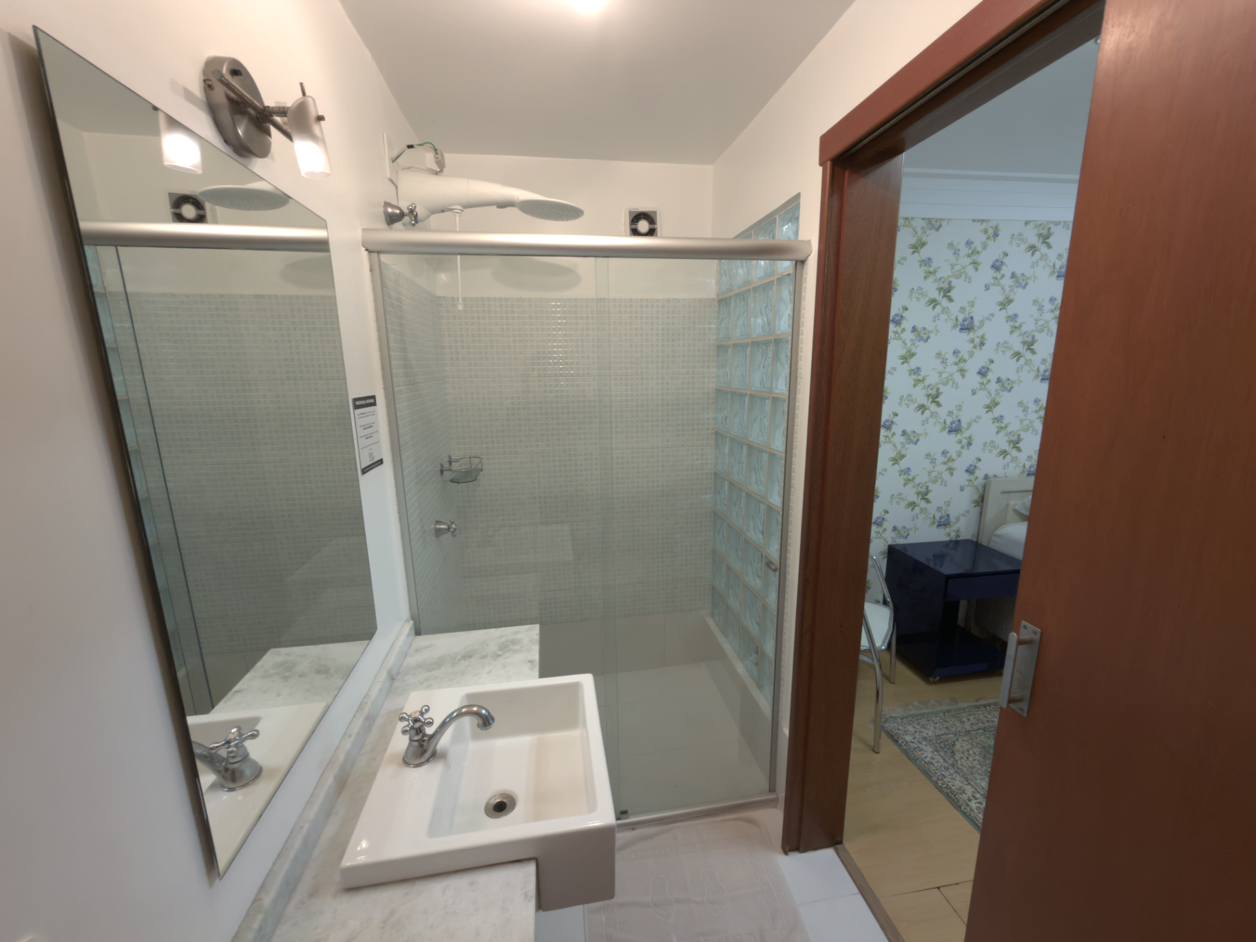 Banheiro com box de vidro e chuveiro quente
