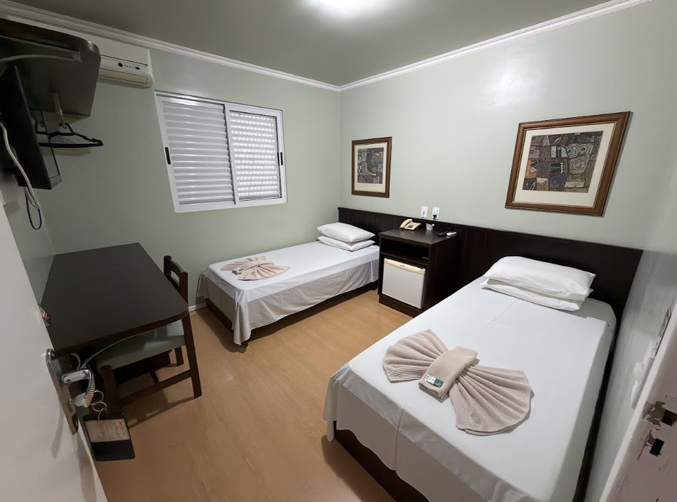 Quarto duplo com duas camas, escrivaninha e frigobar